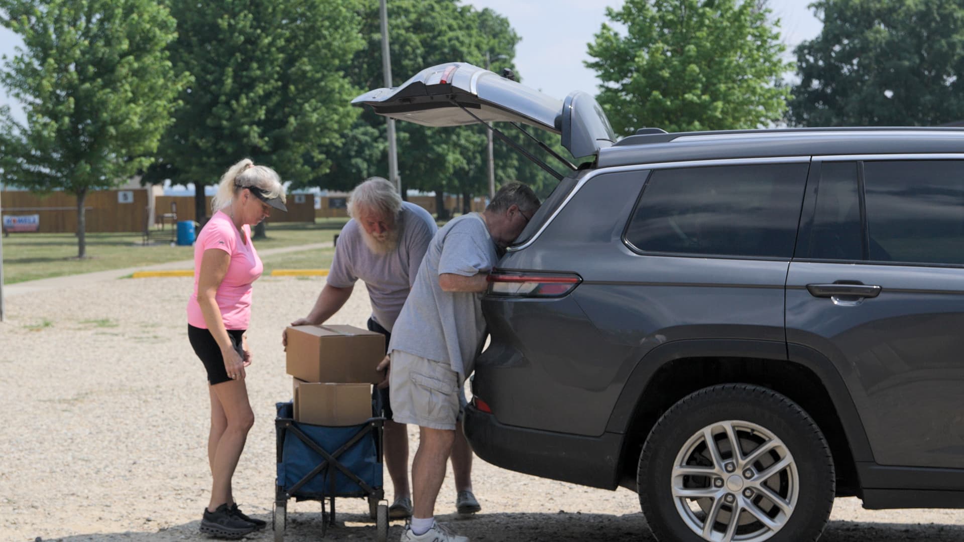 Community volunteers loading meal boxes into a vehicle